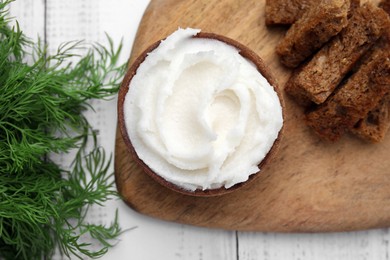 Photo of Delicious pork lard in bowl, crispy rusks and dill on white wooden table, flat lay