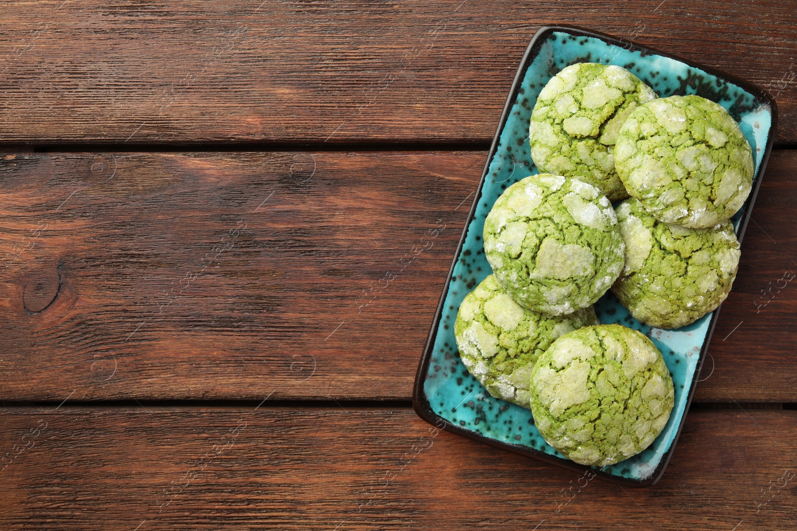 Photo of Plate with tasty matcha cookies on wooden table, top view. Space for text