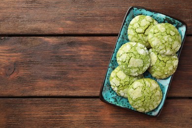 Plate with tasty matcha cookies on wooden table, top view. Space for text