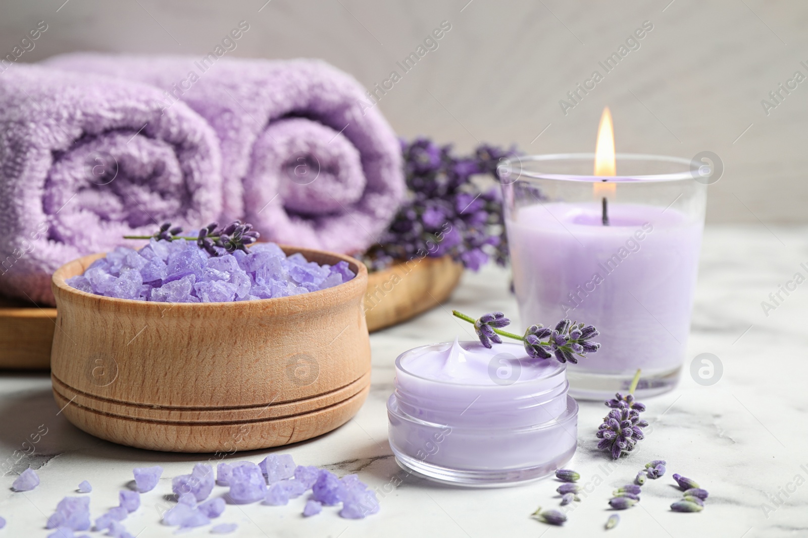 Photo of Cosmetic products and lavender flowers on white marble table