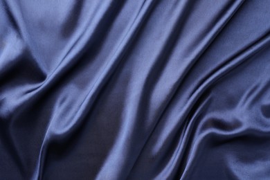 Crumpled dark blue silk fabric as background, top view