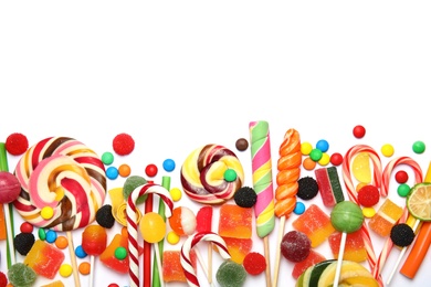 Photo of Many different yummy candies on white background, top view. Space for text