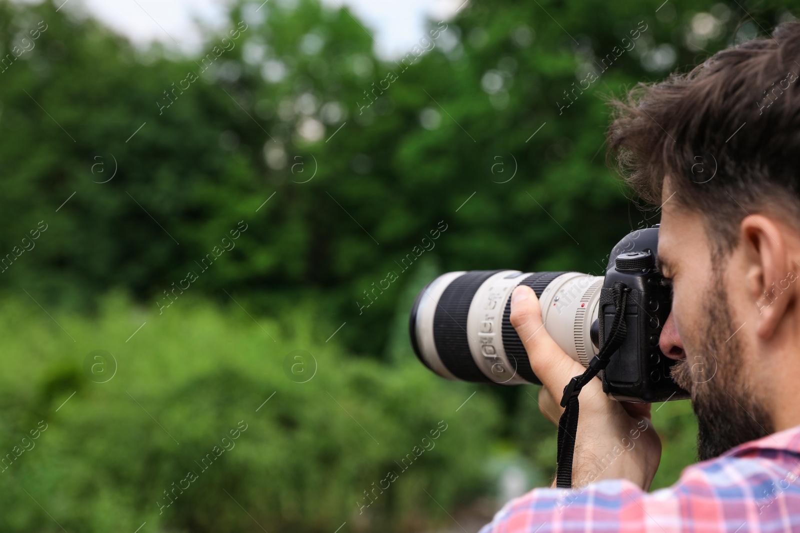 Photo of Photographer taking photo with professional camera in park