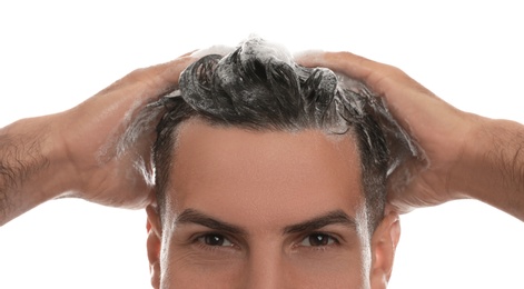 Handsome man washing hair on white background, closeup