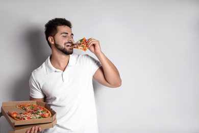 Photo of Handsome man eating pizza on white background, space for text