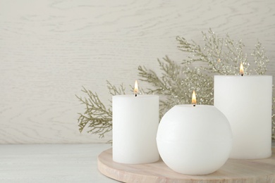 Photo of Beautiful Christmas composition with burning candles on white wooden background. Space for text