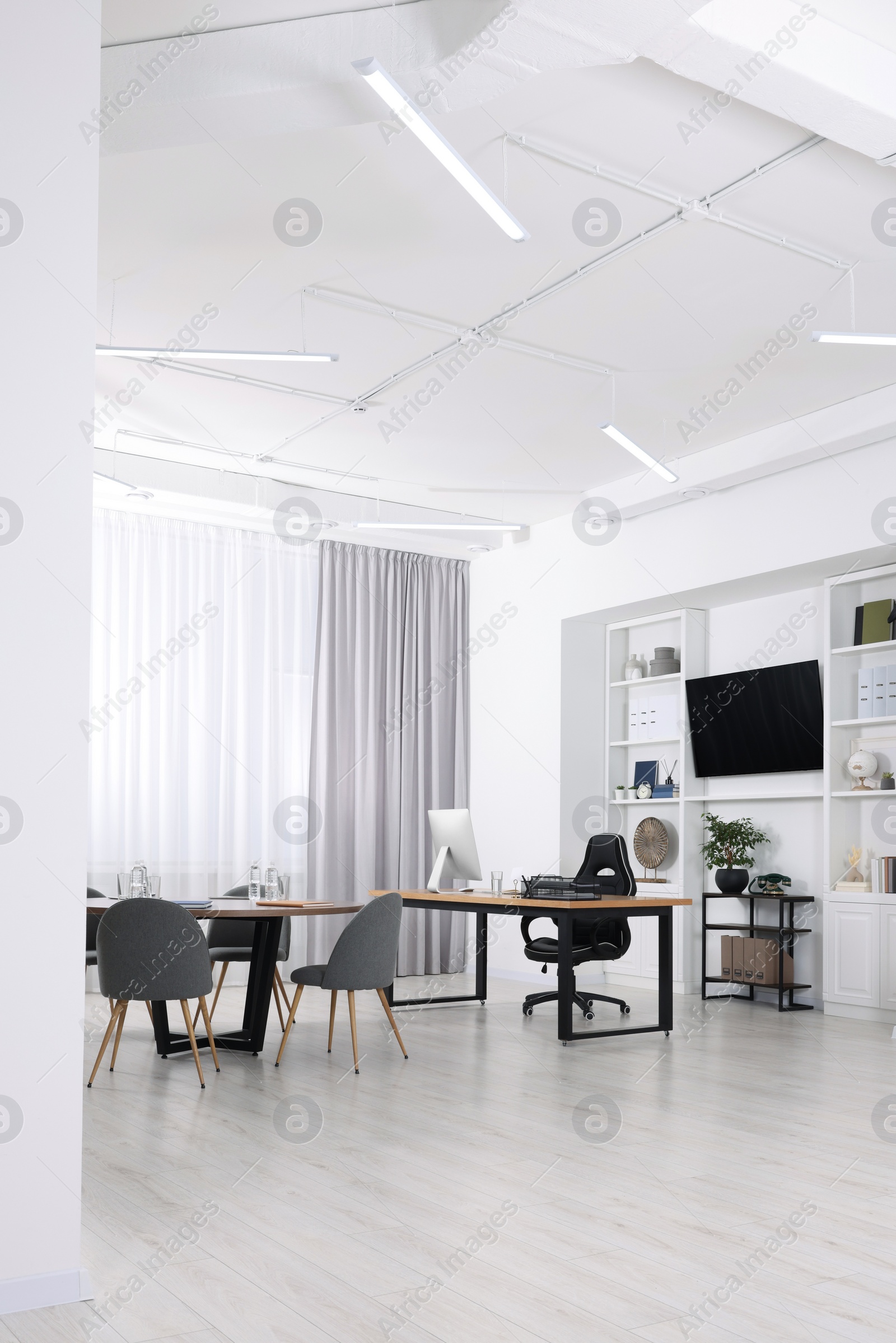 Photo of Stylish office with comfortable furniture and tv zone. Interior design