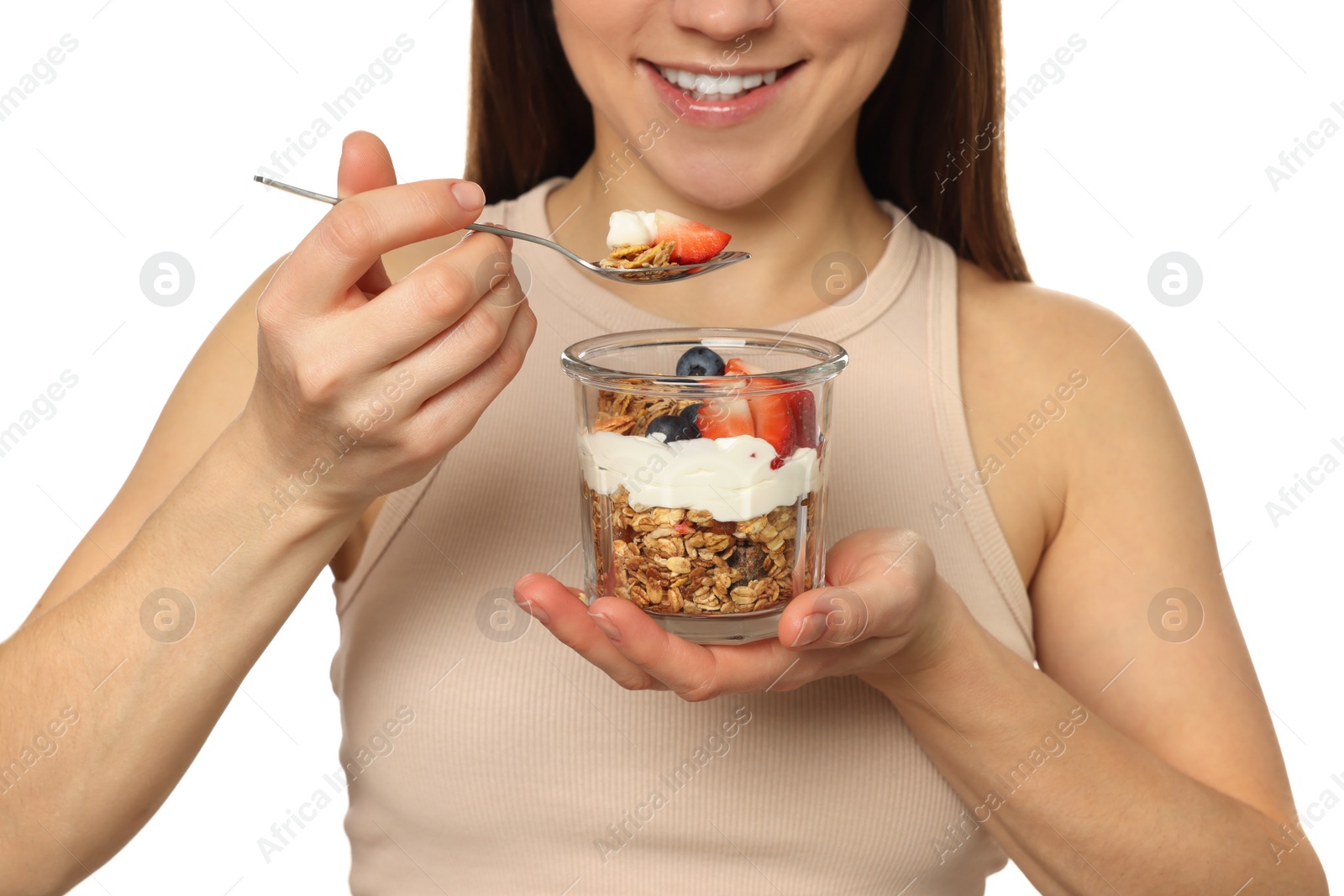 Photo of Happy woman eating tasty granola with fresh berries and yogurt on white background, closeup