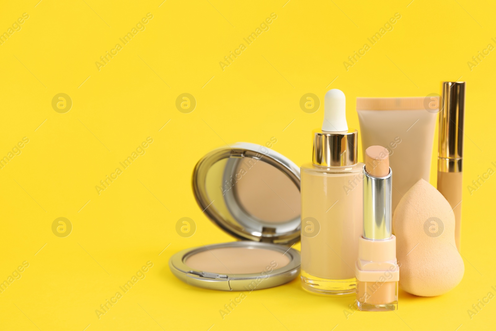 Photo of Foundation makeup products on yellow background, space for text. Decorative cosmetics