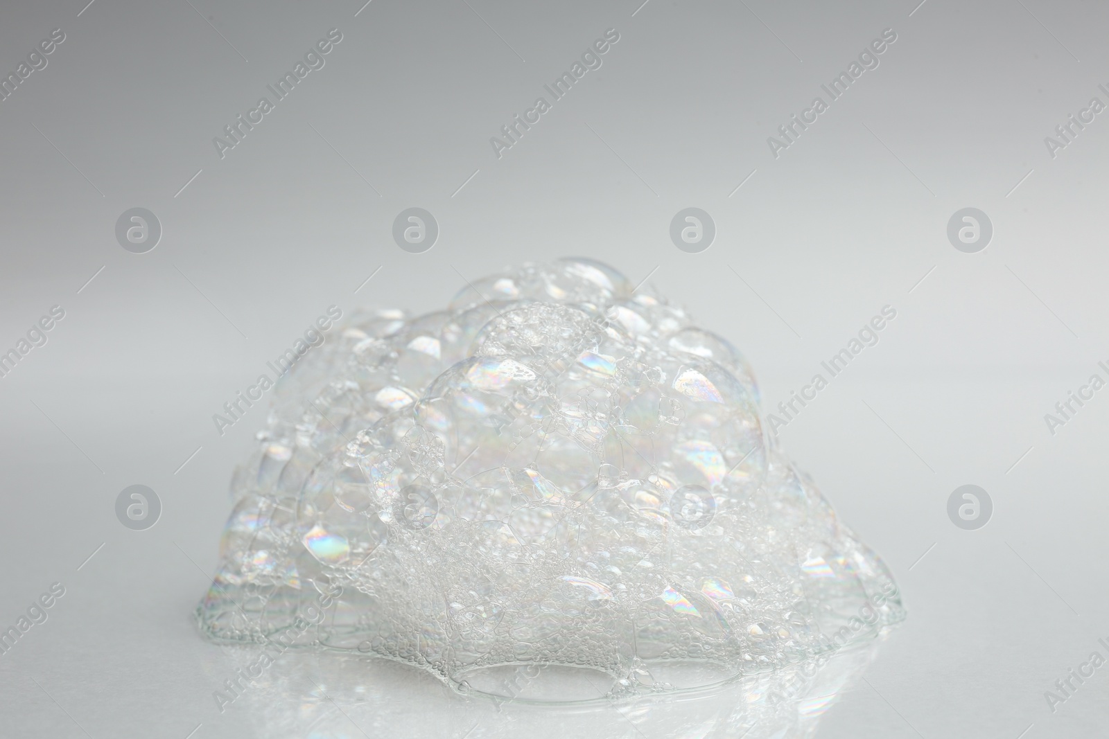 Photo of Drop of fluffy bath foam on light background