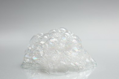 Drop of fluffy bath foam on light background