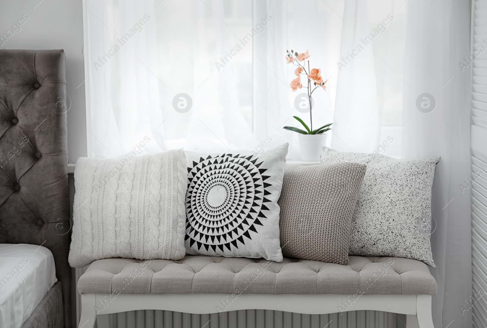 Photo of Sofa bench with soft pillows in elegant bedroom interior