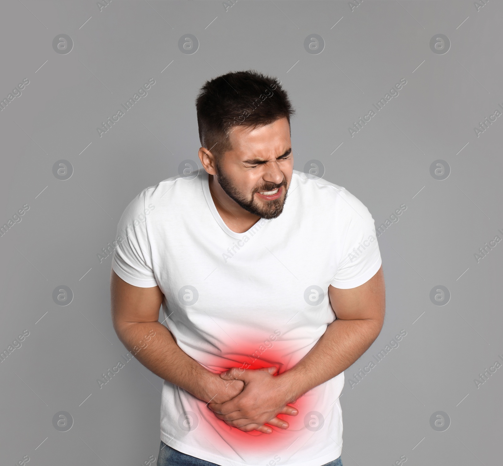 Image of Man suffering from abdominal pain on grey background