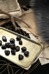 Photo of Tray with many black rune stones on divination mat