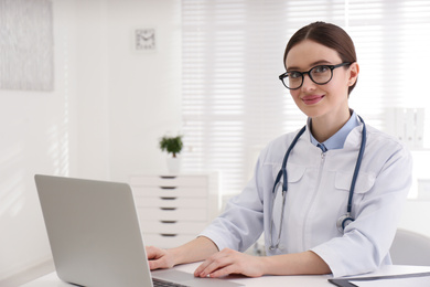 Photo of Portrait of young female doctor in white coat at workplace