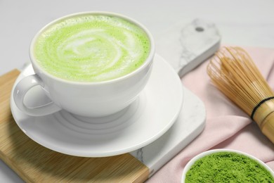 Photo of Cup of fresh matcha latte on white table, closeup