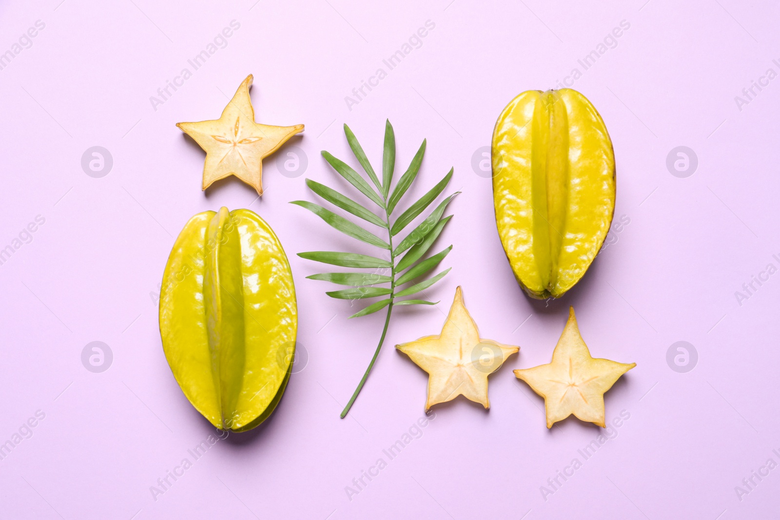 Photo of Delicious carambola fruits on violet background, flat lay