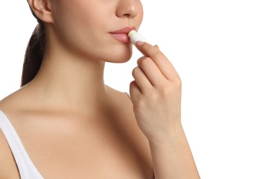 Photo of Young woman applying lip balm on white background, closeup