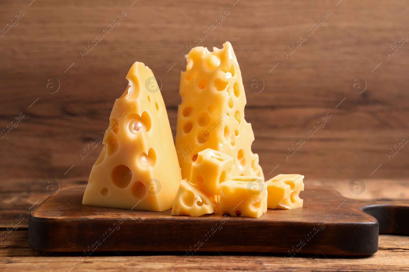 Photo of Pieces of delicious cheese on wooden table