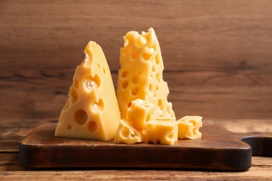 Pieces of delicious cheese on wooden table