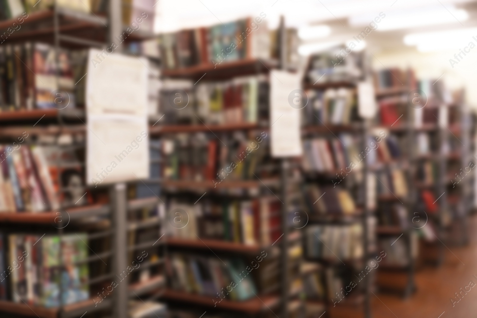 Photo of Blurred view of shelving units with books in library