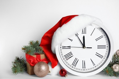 Photo of Clock and festive decor on white background. New Year countdown