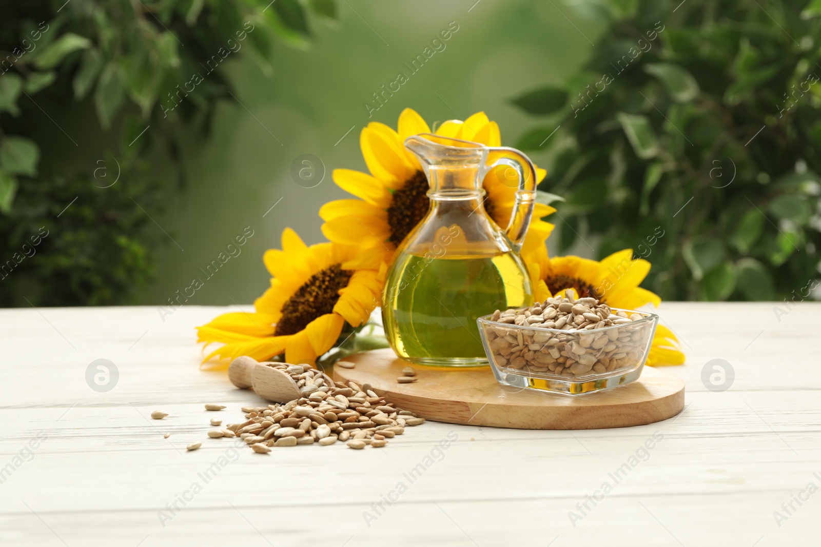 Photo of Composition with sunflower oil on white wooden table against blurred background