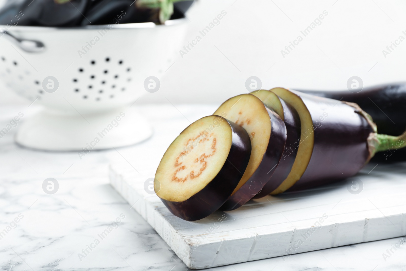 Photo of Wooden board with ripe eggplants on table