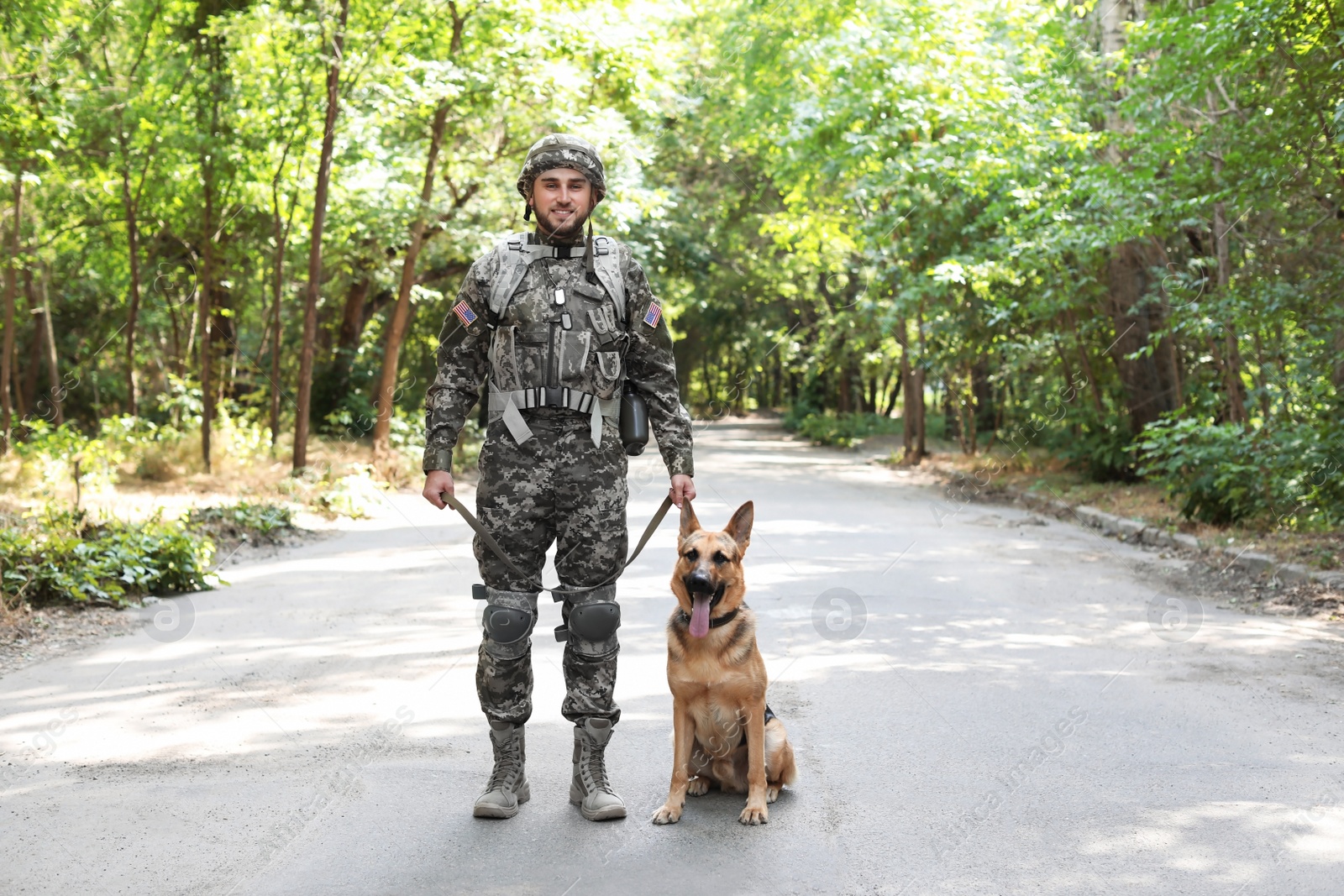 Photo of Man in military uniform with German shepherd dog outdoors