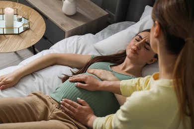 Photo of Doula working with pregnant woman indoors. Preparation for child birth