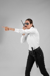 Photo of Female security guard using portable radio transmitter on color background