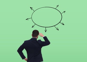 Image of Logic. Man standing in front of diagram on pale green background, back view