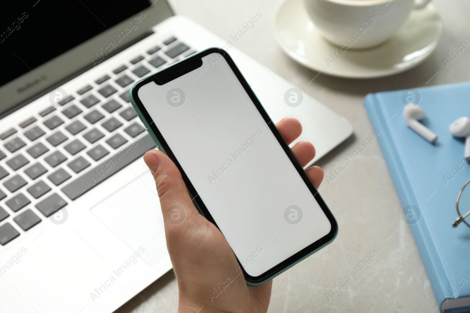 Photo of MYKOLAIV, UKRAINE - JULY 8, 2020: Woman holding Iphone 11 Pro Max with blank screen at workplace, closeup