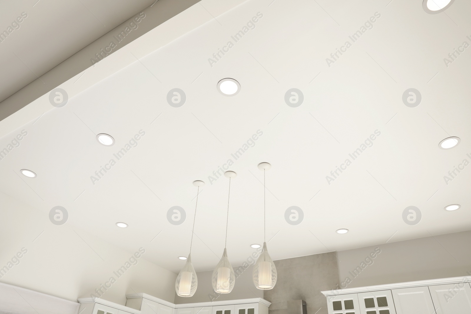 Photo of White ceiling with modern lighting in room, low angle view