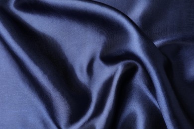 Photo of Crumpled dark blue silk fabric as background, closeup