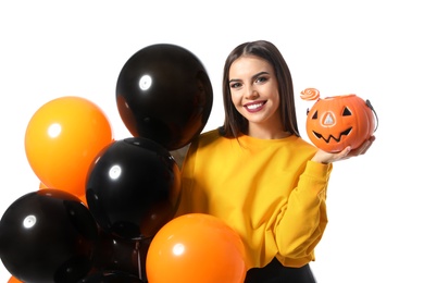 Photo of Beautiful woman with balloons and Jack O'Lantern candy container on white background. Halloween party