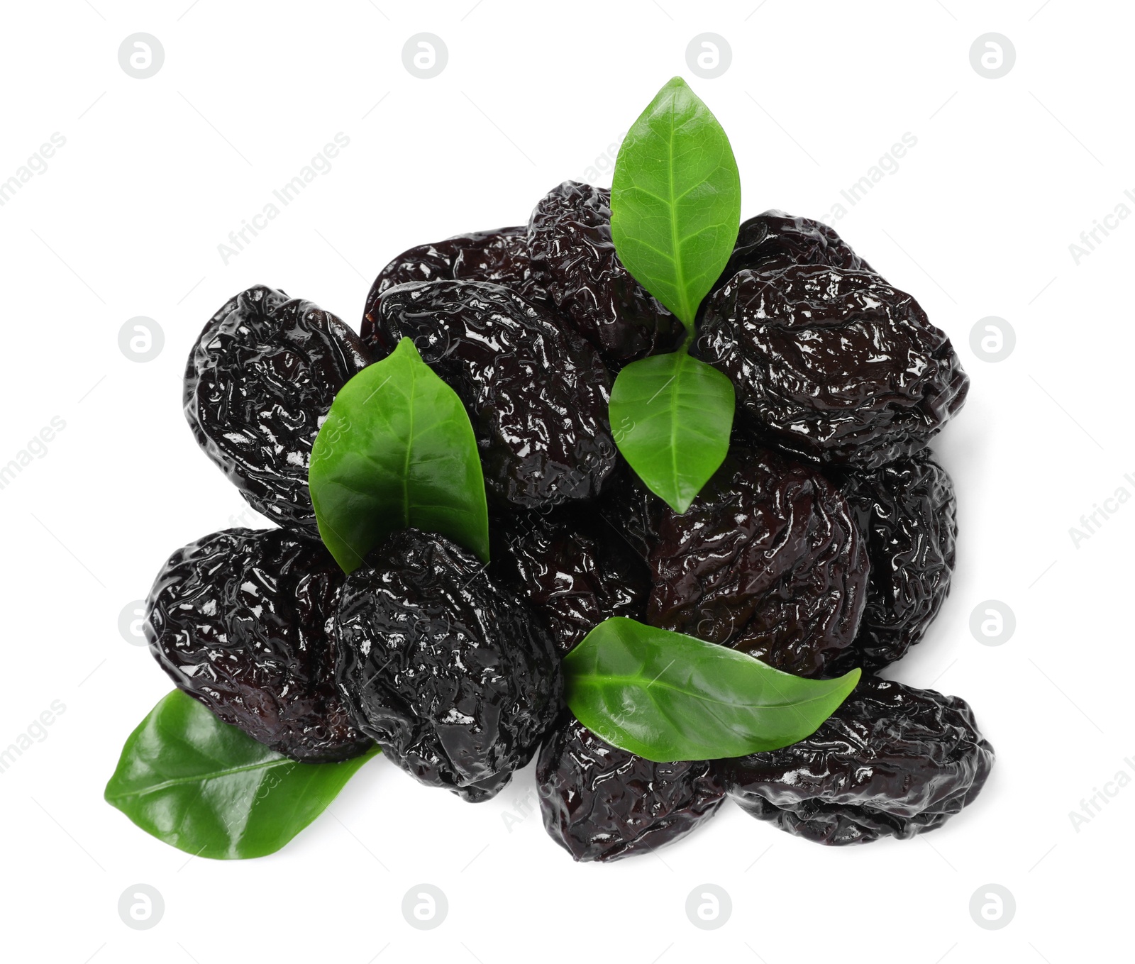 Photo of Heap of sweet dried prunes and green leaves on white background, top view