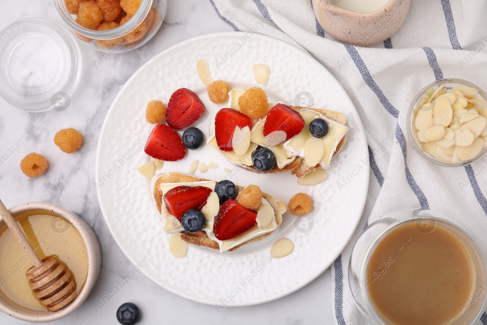 Photo of Tasty brie cheese sandwiches on white marble table, flat lay