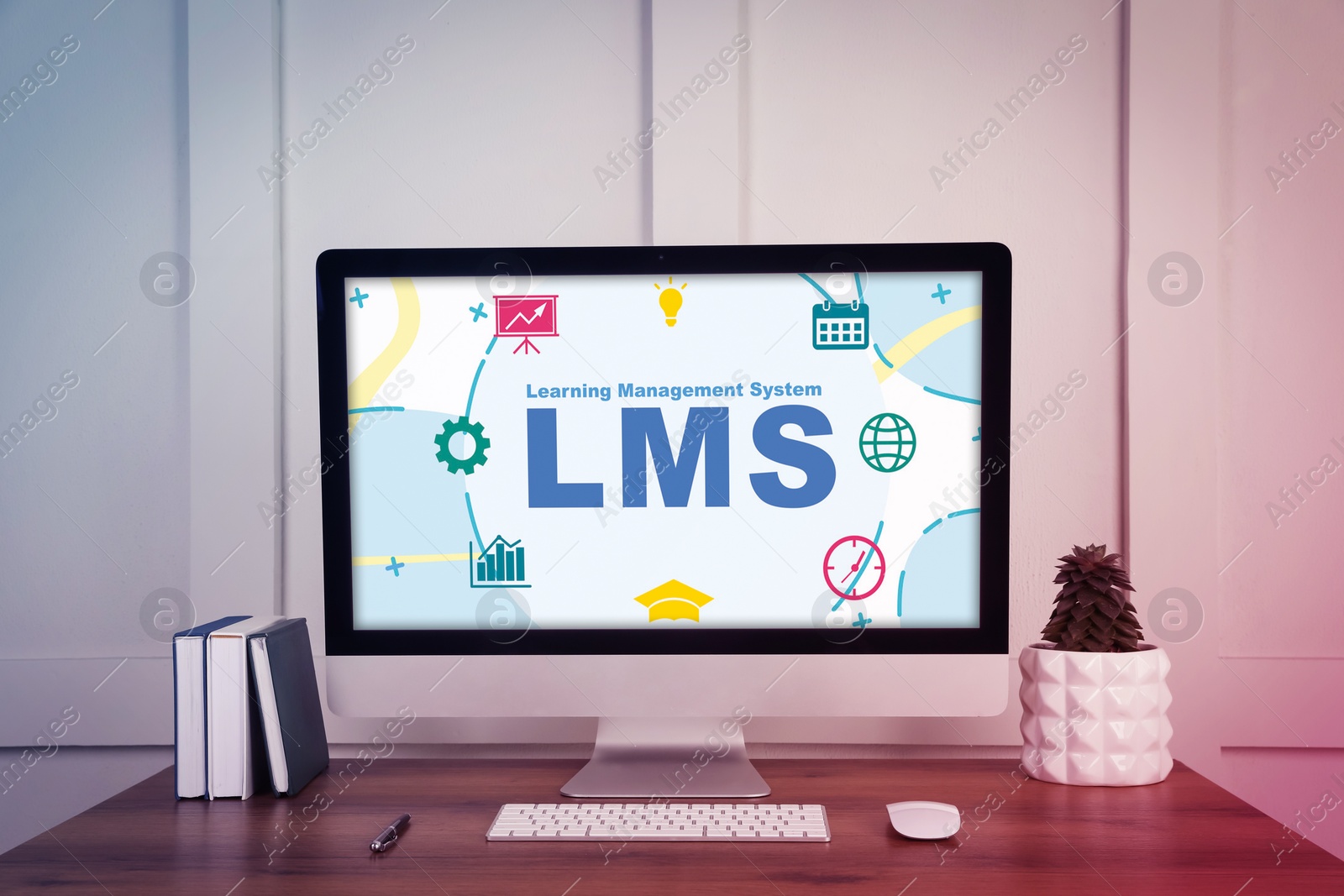 Image of Learning Management System. Computer monitor with different icons and abbreviation LMS on screen. Workplace with modern device, notebooks and houseplant