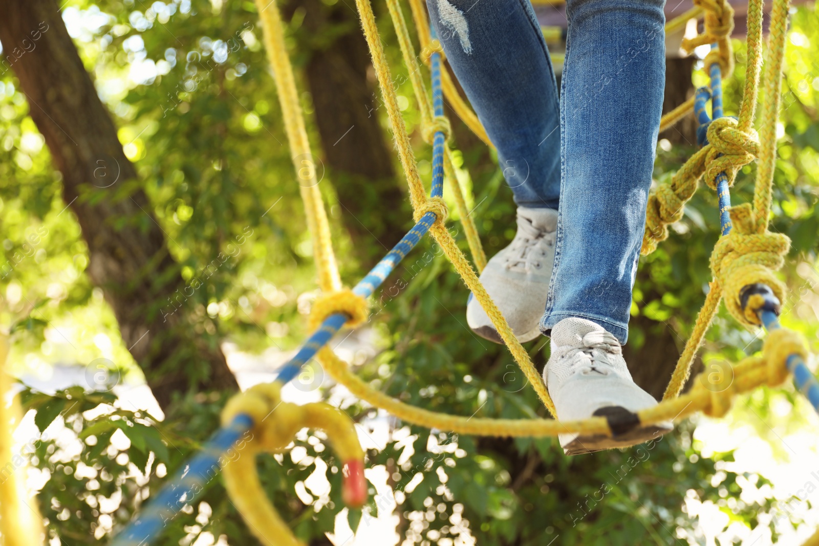 Photo of Child climbing in adventure park, closeup. Summer camp