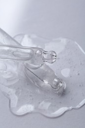 Pipettes with cosmetic serum on white background, closeup