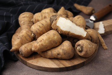Tubers of turnip rooted chervil on brown table, closeup