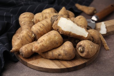 Photo of Tubers of turnip rooted chervil on brown table, closeup