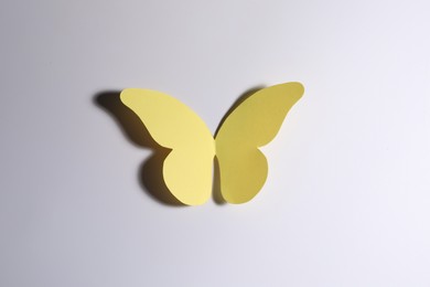 Photo of Yellow paper butterfly on light background, top view