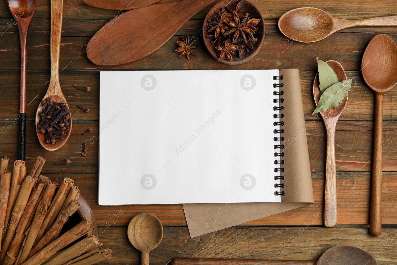 Photo of Blank recipe book, spices and kitchen utensils on wooden table, flat lay. Space for text