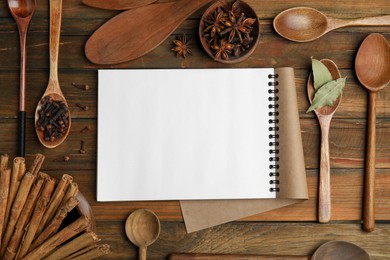 Photo of Blank recipe book, spices and kitchen utensils on wooden table, flat lay. Space for text