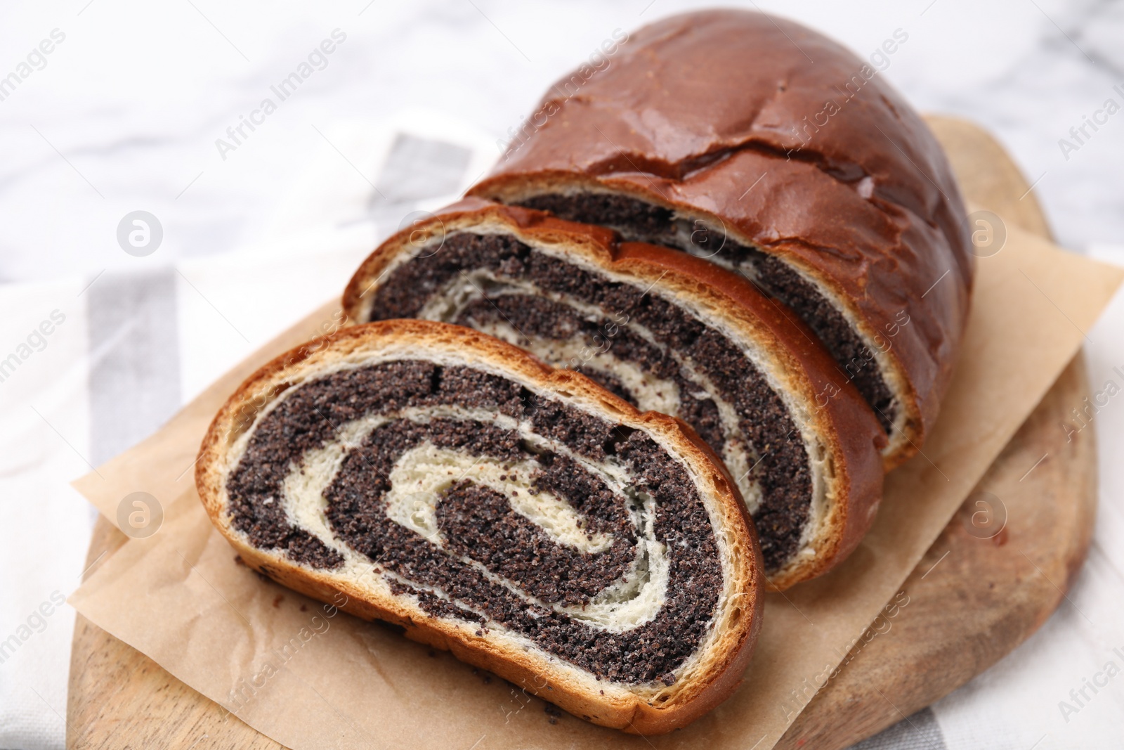 Photo of Cut poppy seed roll on table, closeup. Tasty cake