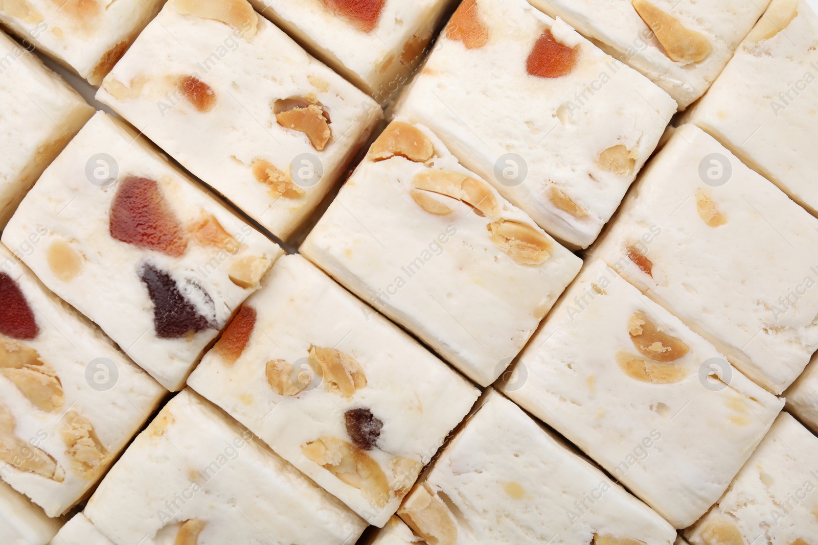 Photo of Pieces of delicious nougat as background, top view