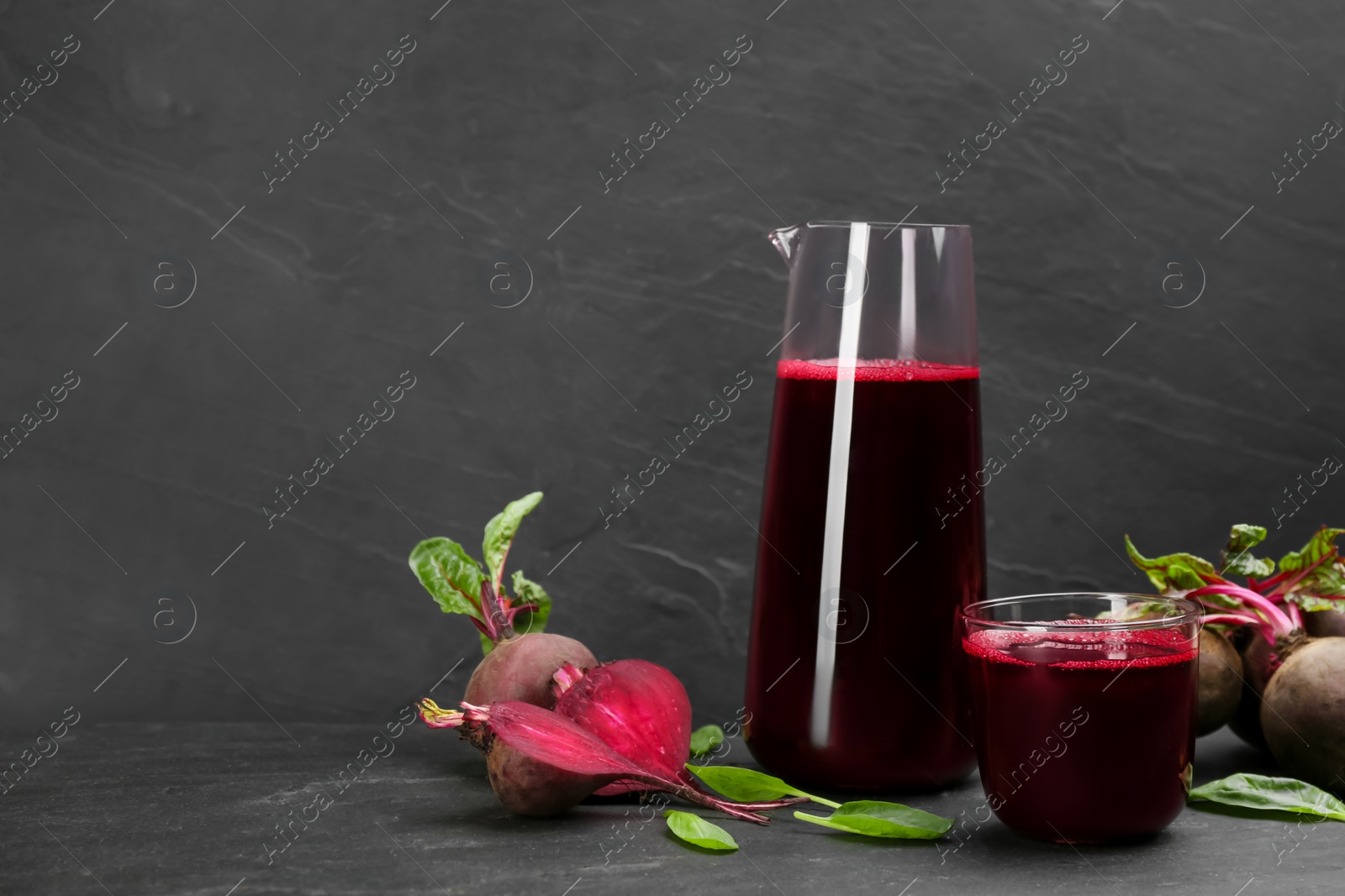 Photo of Freshly made beet juice on black table. Space for text