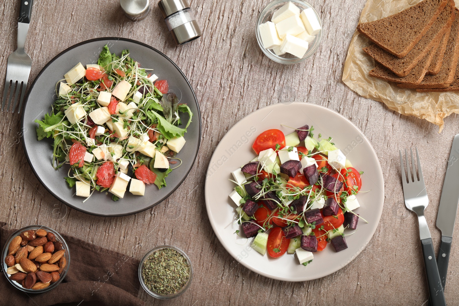 Photo of Delicious carrot salads served on wooden table, flat lay